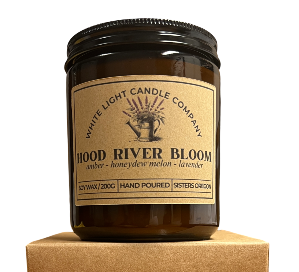 Candle jar with 'Hood River Bloom' label on a matching cardboard box against a white background