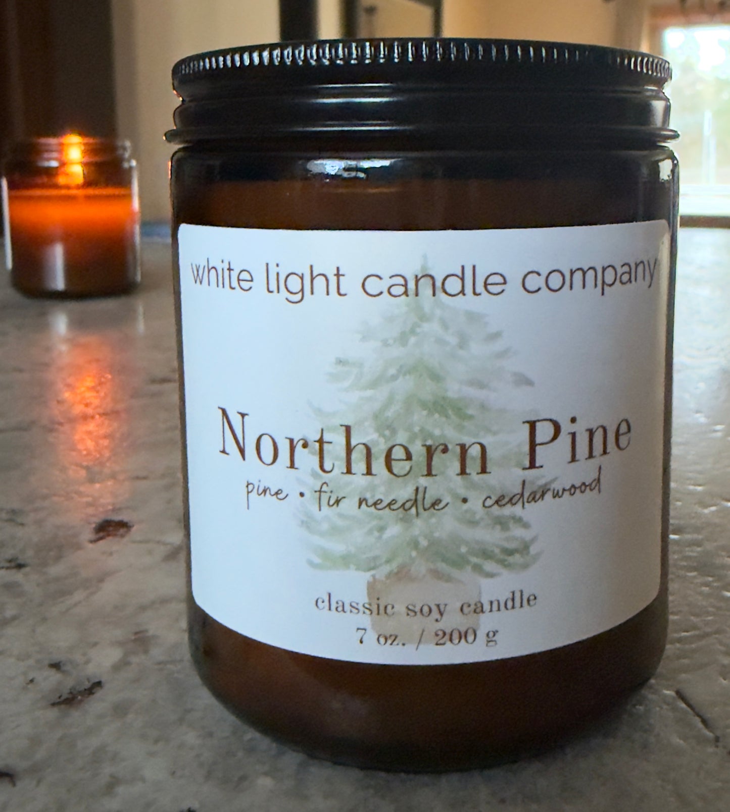 Candle jar labeled 'Northern Pine' from White Light Candle Company on a marble surface.