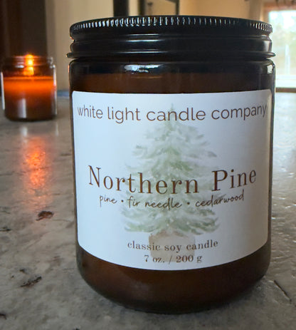 Candle jar labeled 'Northern Pine' from White Light Candle Company on a marble surface.